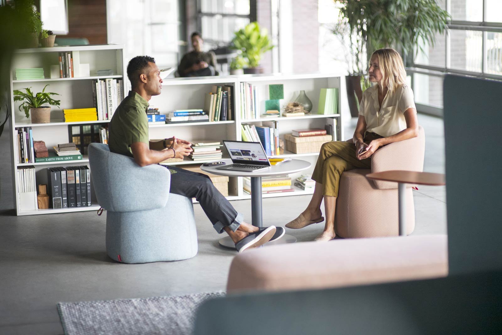 Two workers having a quiet conversation in a comfortable workspace