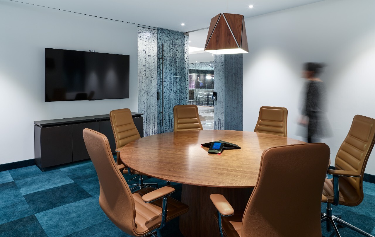 Law firm conference room with round table and privacy-forward layout designed for confidential client meetings